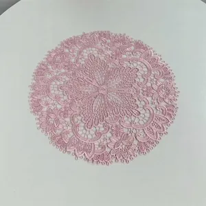 Detailed view of intricate pink embroidered lace placemat with floral openwork pattern