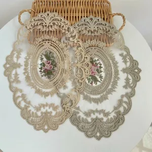 Sierlijke vintage geborduurde kanten placemat met bloemmotief op witte tafel