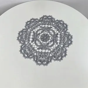 Close-up of the intricate gray embroidered lace placemat showing detailed floral patterns.