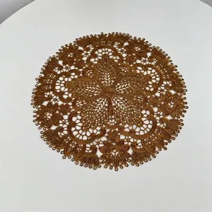 Detailed view of intricate bronze embroidered lace doily with floral patterns.