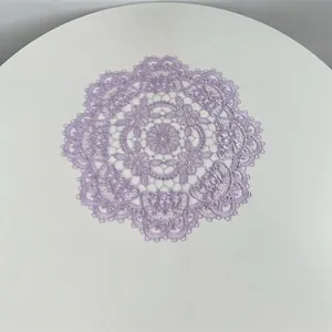 Close-up of a circular purple lace placemat featuring intricate floral embroidery