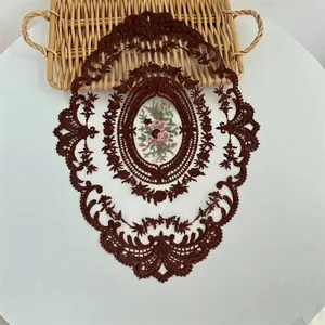 Prachtige vintage ovale bruine kanten placemat met bloemenborduursel op witte tafel
