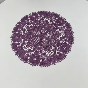 Detail view of the intricate purple embroidered lace pattern on the circular placemat