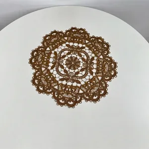 Close-up of intricate vintage style circular lace embroidered placemat on white table