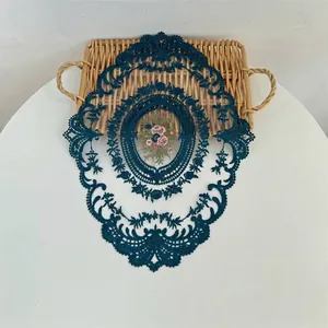 Vintage blauwe kanten placemat met roze bloemenborduurwerk op witte tafel