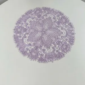 Macro detail of purple embroidered lace doily with intricate hollow floral patterns