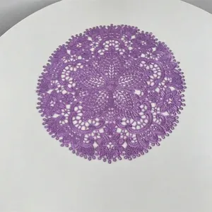 Close-up of purple embroidered lace placemat with intricate floral hollow design