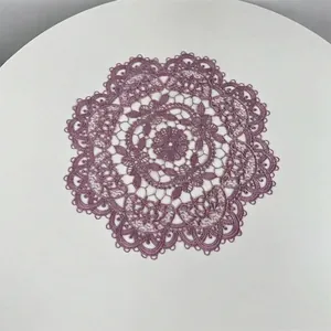 Detailed view of an intricate purple embroidered lace doily with elegant hollow-out floral patterns