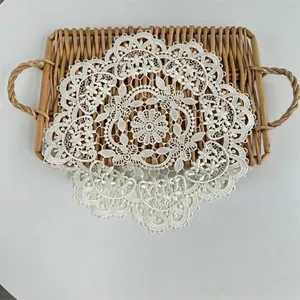 Close-up detail of a white embroidered floral lace doily on a wicker tray.