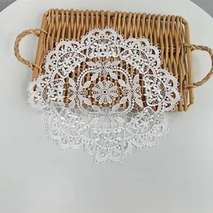 Detailed view of the intricate white embroidered lace pattern on a round placemat.