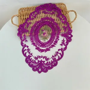 Gedetailleerd overzicht van paars geborduurde kanten placemat met een elegant bloemmotief