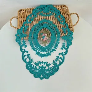 Detailweergave van een blauwgroen geborduurd placemat met bloemmotief