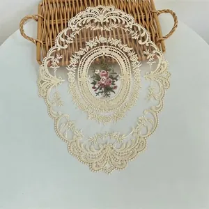 Gedetailleerde close-up van een elegante beige kanten placemat met geborduurde bloemen
