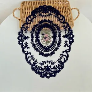 Detailopname van het ingewikkelde bloemenborduurwerk op donkerblauwe kanten placemat