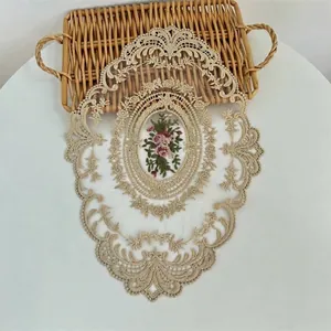 Gedetailleerd overzicht van bloemenborduurwerk op vintage kant placemat loper.