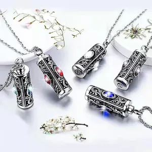 Detailed view of cylindrical cremation necklaces with various birthstones and filigree.