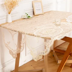 Elegant lace embroidered table runner with intricate hollow floral patterns on a wooden table.