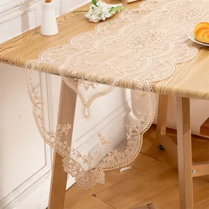 Detailed view of elegant champagne lace table runner with intricate floral embroidery