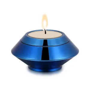 Detail view of a blue metallic stainless steel memorial urn with a lit candle top