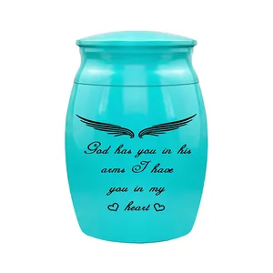 Detailed view of cyan mini cremation urn featuring engraved memorial quote and wings motif