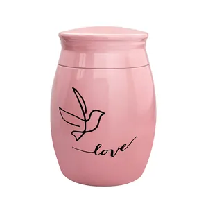 Detailed view of a pink memorial cremation urn featuring a bird and Love engraving pattern