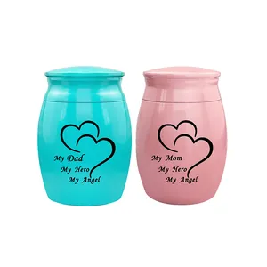Detailed view of pink and turquoise mini urns with heart design and commemorative text.