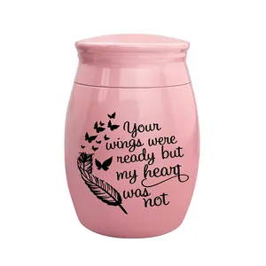 Detail view of pink memorial urn with heart-touching message and butterfly motifs