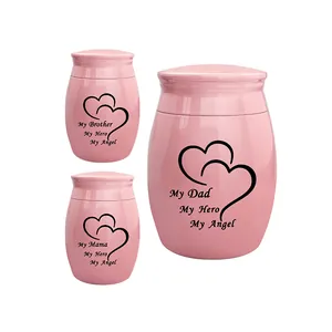 Set of pink memorial cremation urns with heart pattern and engraved text for family