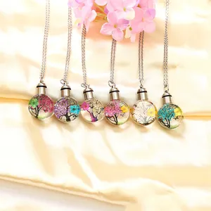 Close-up view of multiple memorial glass urn necklaces with colorful dried flower designs.
