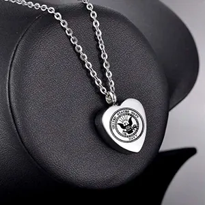 Close-up of heart-shaped stainless steel cremation urn pendant with United States Navy seal