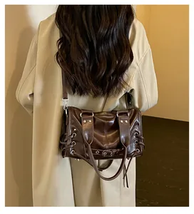 Detailansicht einer dunkelbraunen Leder-Motorradtasche über einem beigen Trenchcoat