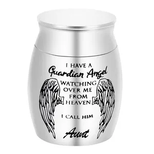 Close-up of silver cremation urn with guardian angel engraving and memorial text.