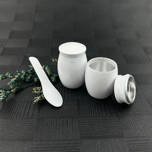 Close-up detail view of small white cremation urn set with spoon and metal interior.