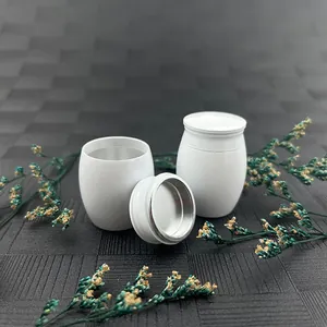 Close-up of white mini memorial urn with screw-top lid and floral decoration