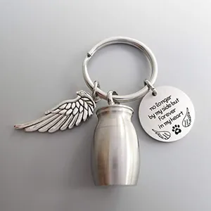 Detalle del llavero de urna conmemorativa con ala de ángel y placa grabada sentimental