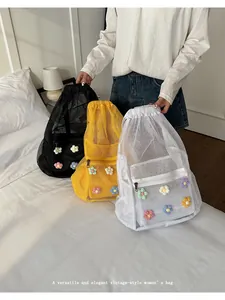 Tres mochilas de malla coloridas con decoraciones de flores tejidas en cuarto