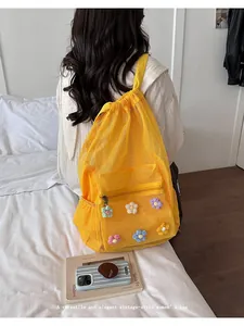 Primer plano de una elegante mochila de malla amarilla con detalles de flores de ganchillo