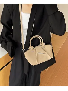 Elegante borsa a mano beige a pieghe abbinata a un blazer nero per un look da ufficio.