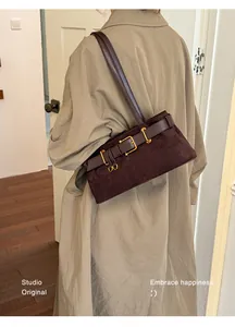 Detailansicht einer braunen Wildleder-Baguette-Tasche, kombiniert mit einem Trenchcoat