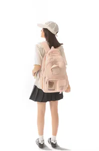 Rear view of a light pink Korean style backpack worn by a model in casual school outfit