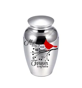 Urna funeraria para mascotas en metal plateado con cardenal rojo y frase conmemorativa