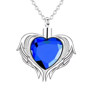 Dettaglio ravvicinato di una collana con urna a cuore, cristallo blu e ali d'angelo.
