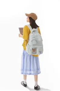 Female student wearing a stylish mint green Korean backpack in a studio setting