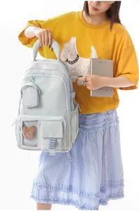 Detailed view of light blue padded backpack with cute bear charm and top handle