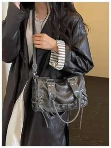 Detailansicht einer grauen Motorradtasche aus weichem Leder mit Nieten und Schnürung.