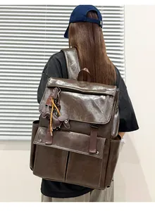 Vue arrière d'un sac à dos vintage en cuir marron porté par une personne stylée