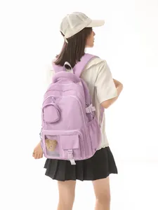 Modern purple casual school backpack for girls featuring a cute teddy bear charm detail