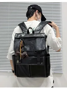 Vue arrière du sac à dos en cuir vintage noir avec coutures blanches et breloque chien