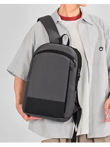 Detailweergave van een grijze waterdichte nylon laptoprugzak op een herenmodel.