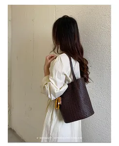 Detailansicht der Retro-Ledertasche mit Flechtmuster am Modell vor einer weißen Wand